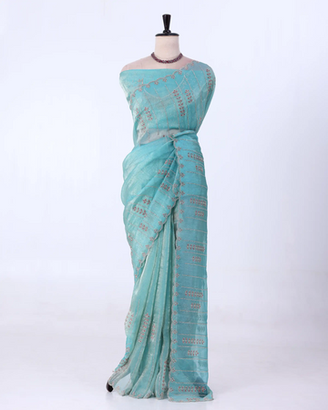 A light turquoise blue saree with metallic gold zari embroidery