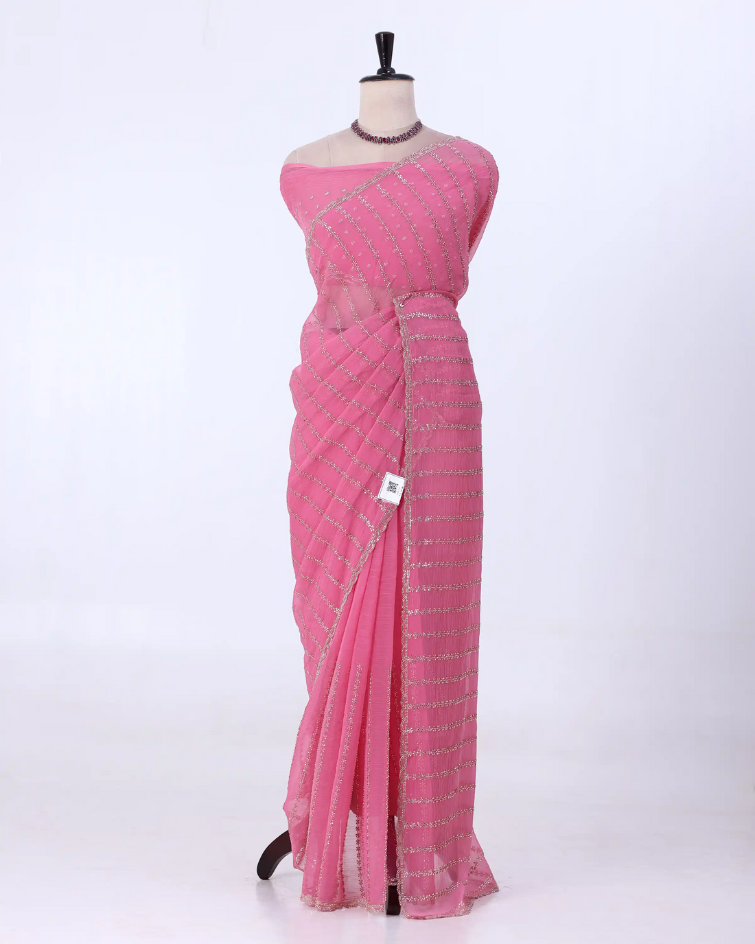 A pink saree with silver sequin stripes with matching blouse
