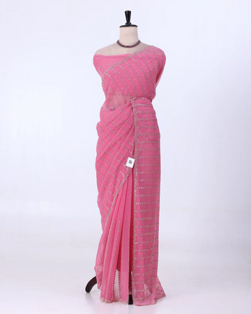 A pink saree with silver sequin stripes with matching blouse