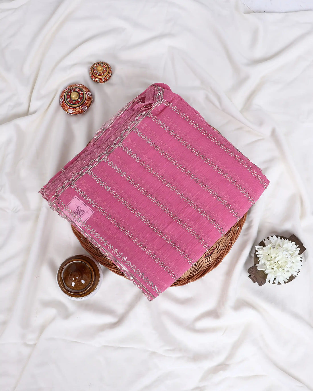 A pink saree with silver sequin stripes with matching blouse