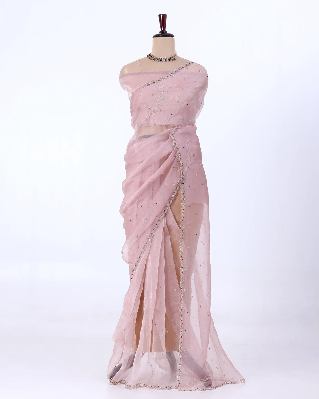A light pink saree with silver mirror work and bead borders