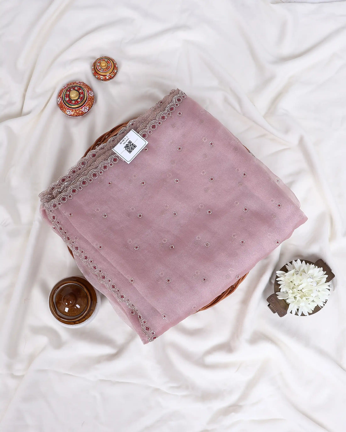 A light pink saree with silver mirror work and bead borders