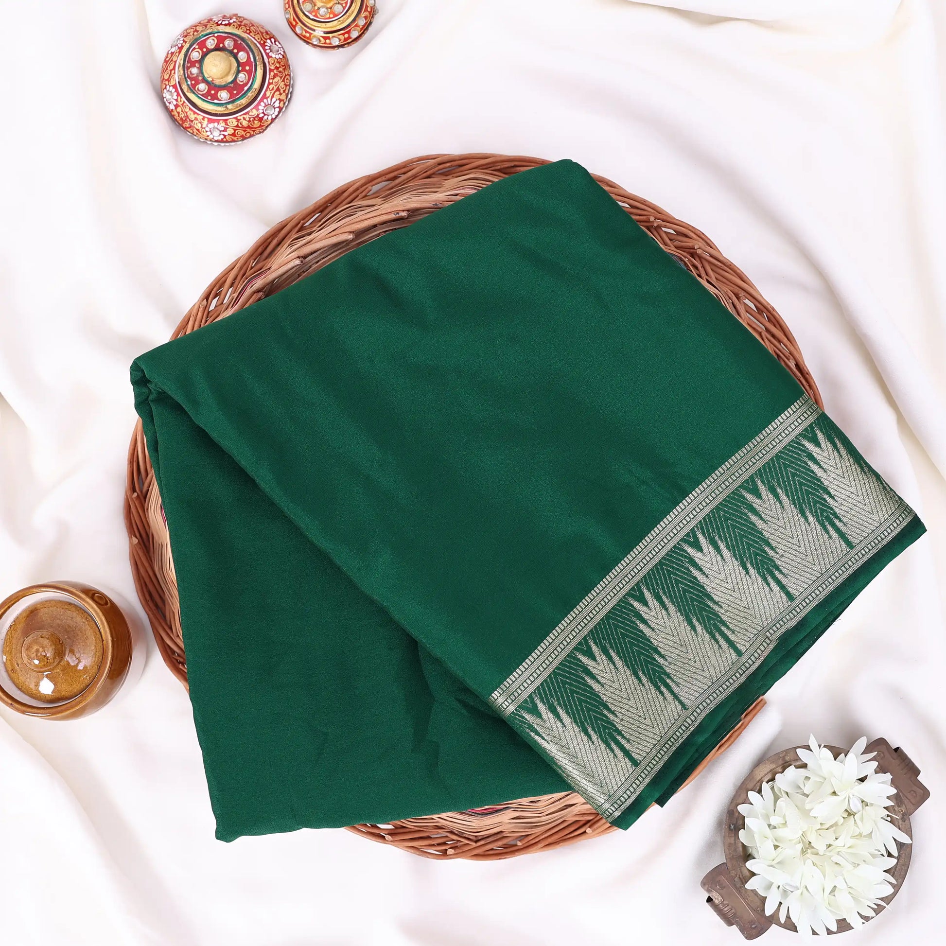 A folded dark green sareewith a decorative border pattern