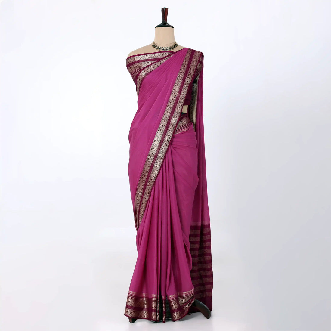 A magenta and pink saree with a maroon border and a maroon pallu, accented with gold zari metallic patterns.