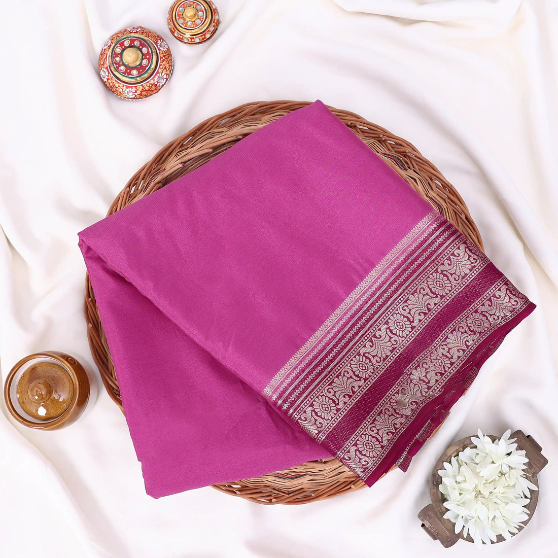 A magenta and pink saree with a maroon border and a maroon pallu, accented with gold zari metallic patterns.