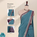 A teal blue saree with a deep purple border and silver zari embroiderywith detail of  head, blouse, and pallu 