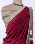 A close-up of a draped saree , featuring a deep magenta-pink body with fine silver stripes and a beige blouse. 