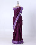A purple silk saree with subtle vertical stripes and a matching purple border