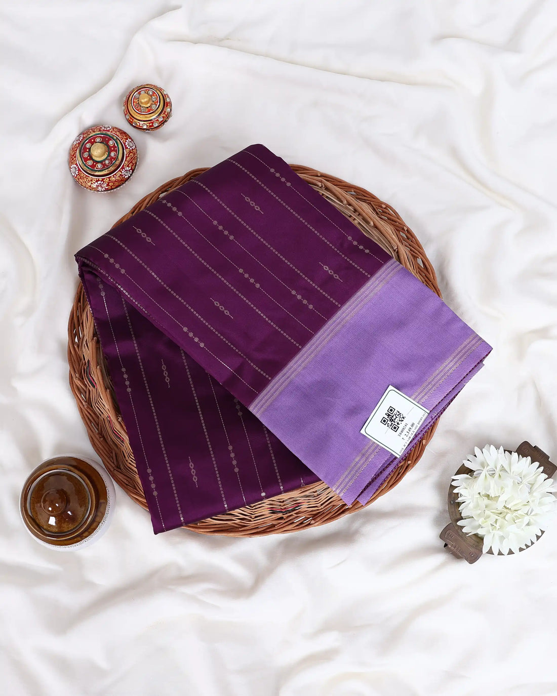 A purple silk saree with subtle vertical stripes and a matching purple border