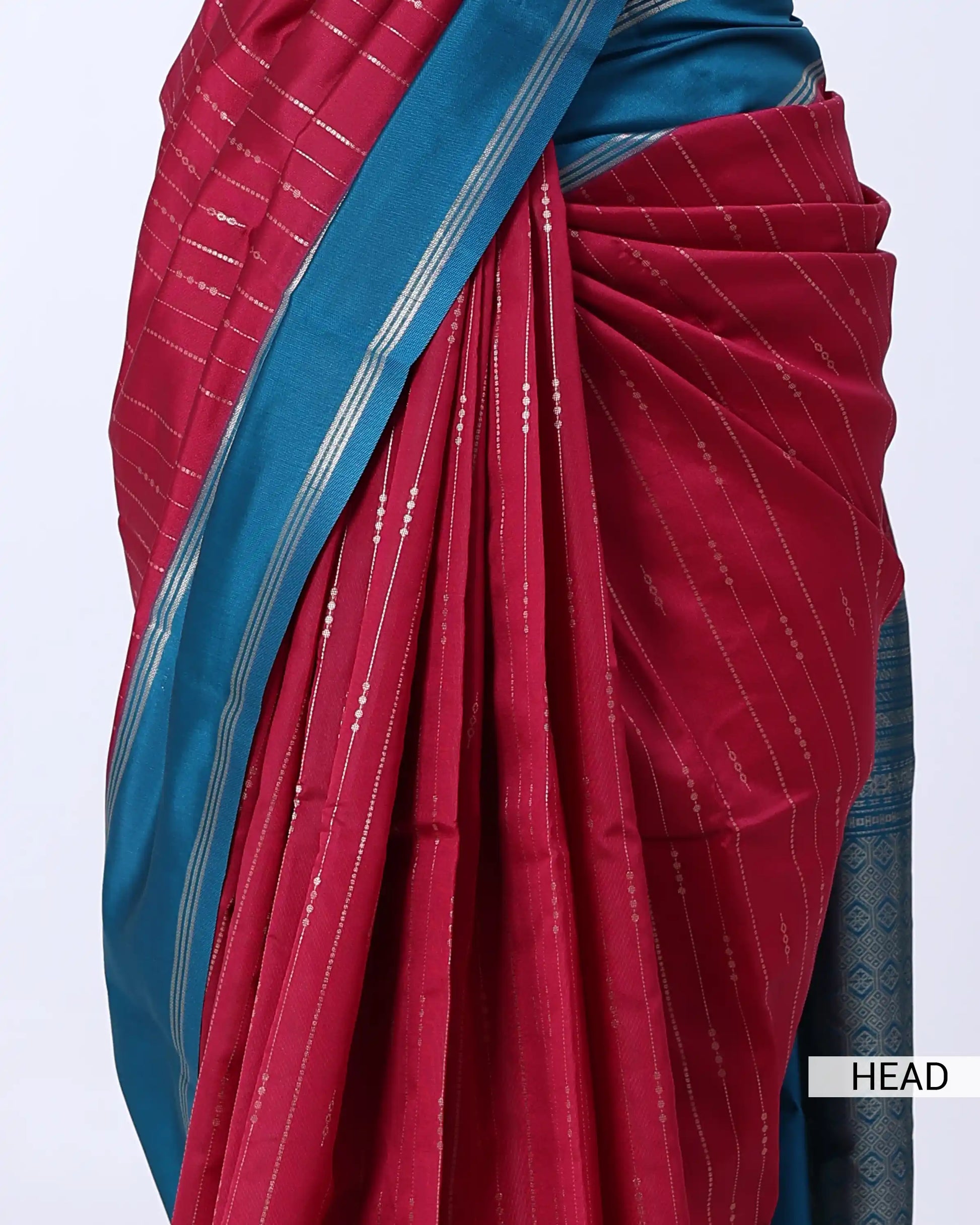 A close-up of a draped red and teal blue saree with fine silver vertical stripes 