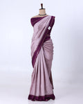 A lavender purple silk saree with a contrasting deep purple border and matching blouse