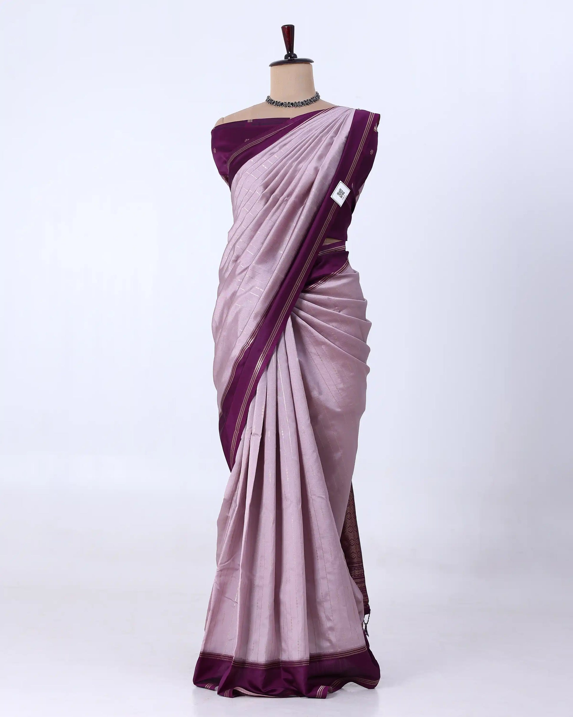 A lavender purple silk saree with a contrasting deep purple border and matching blouse