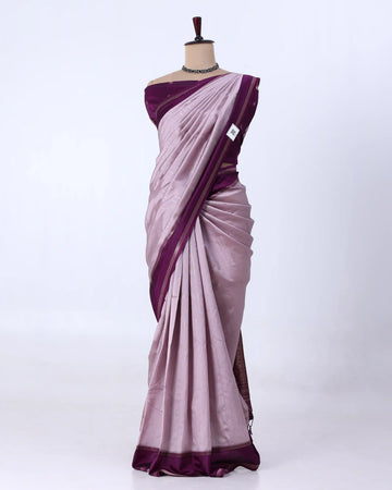 A lavender purple silk saree with a contrasting deep purple border and matching blouse