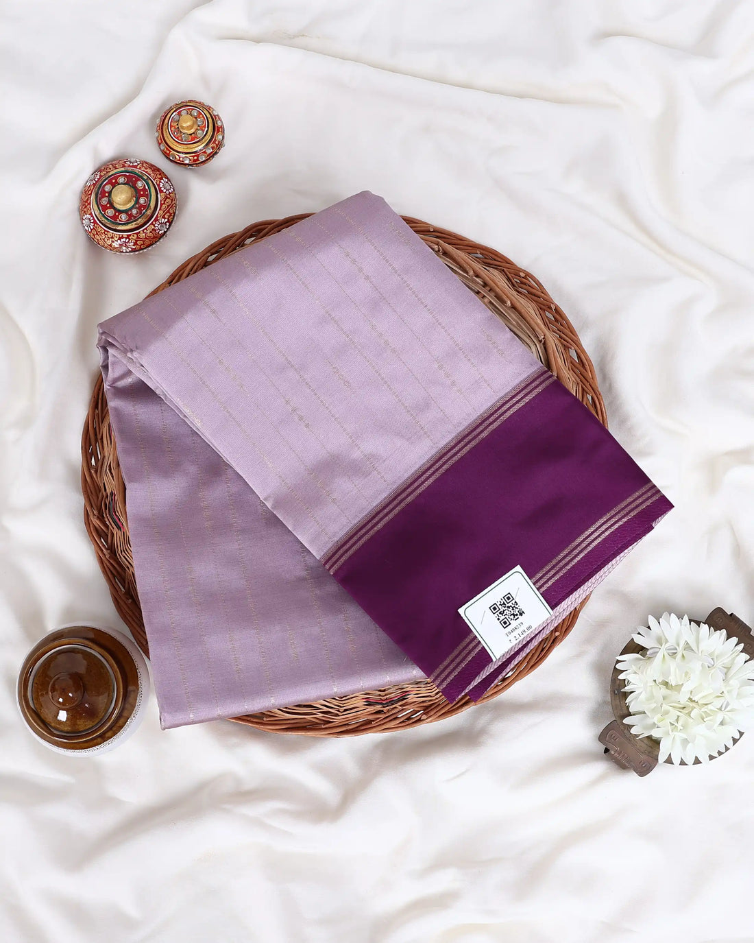 A lavender purple silk saree with a contrasting deep purple border and matching blouse