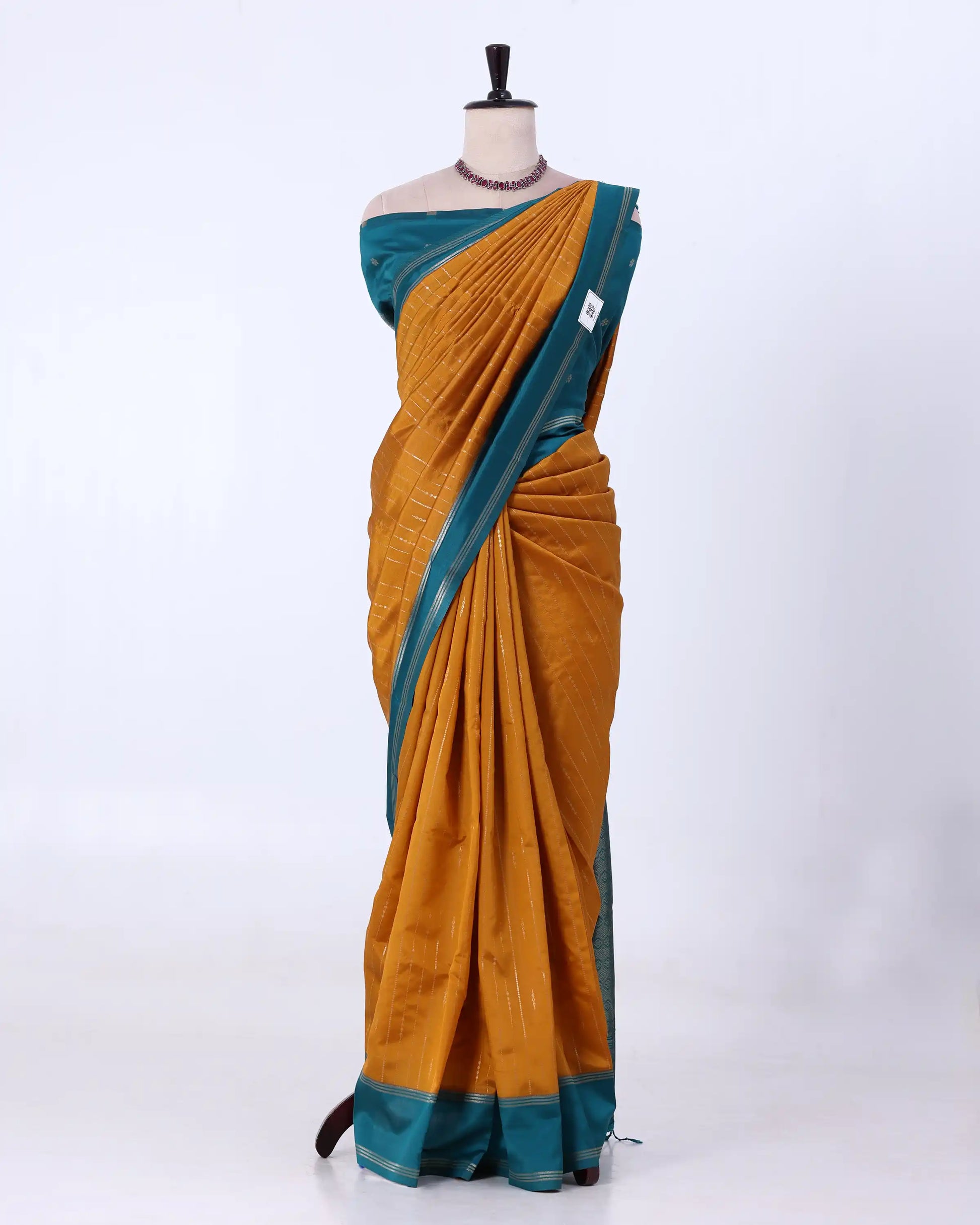A mustard yellow and teal saree with matchung blouse
