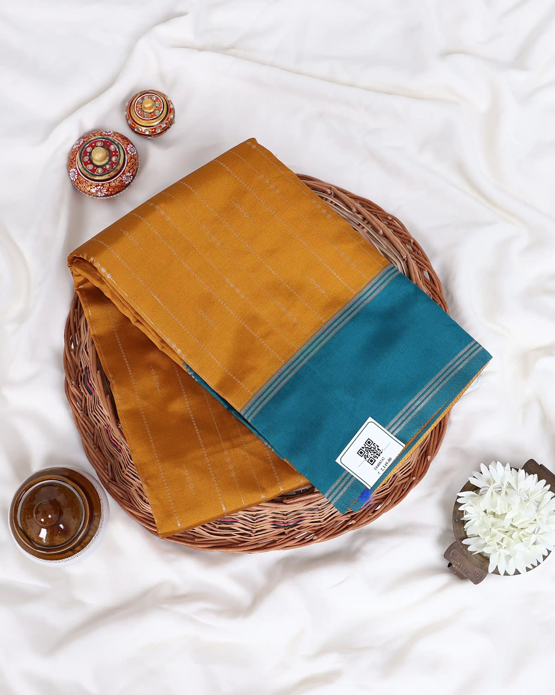 A folded mustard yellow and teal saree 