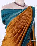 A teal and mustard yellow saree draped on a mannequin torso, styled with a matching teal blouse 